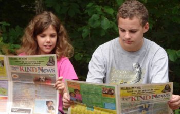photo of boy and girl reading kind news